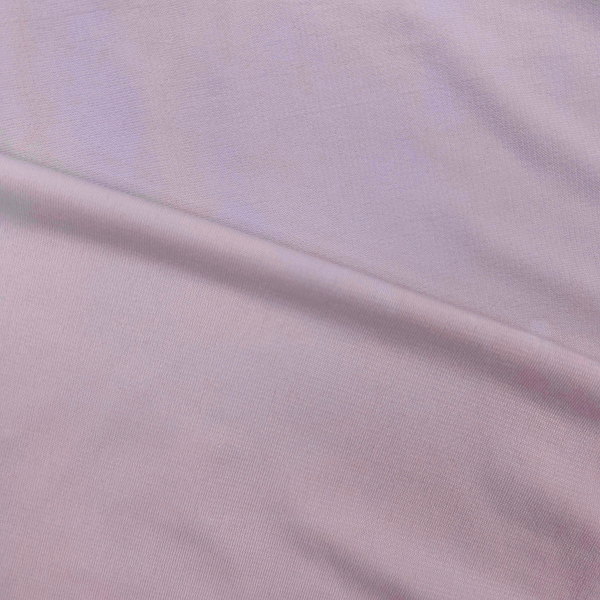 A close-up of a light pink or pale lavender knit fabric with soft folds and a subtle sheen.