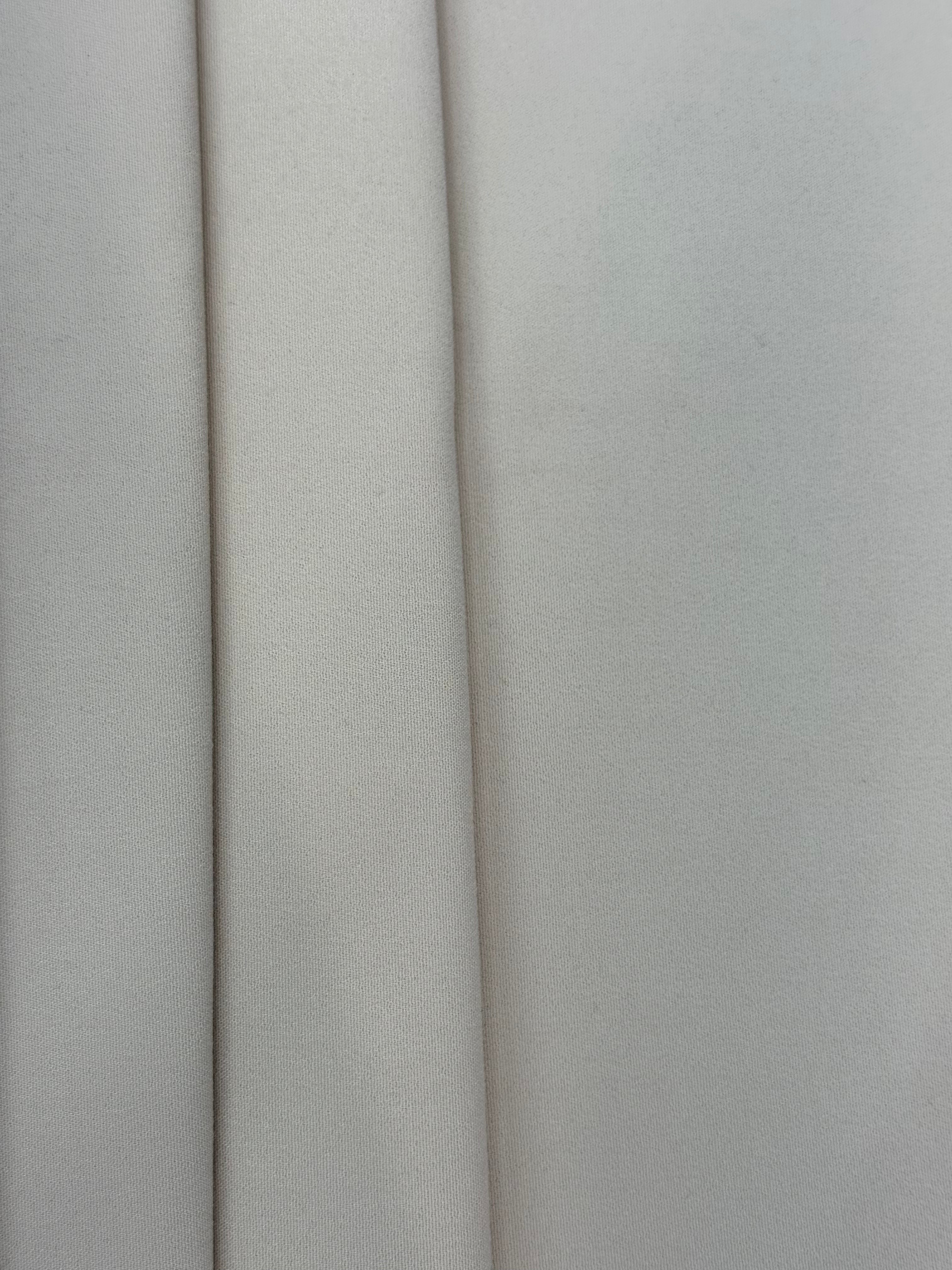 Beige cotton stretch suiting fabric with a fine woven texture and soft vertical folds.