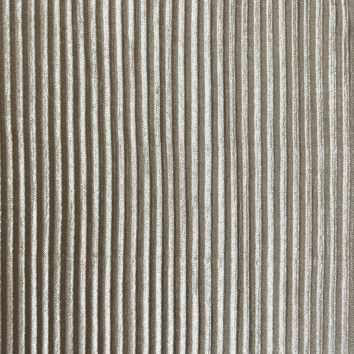 A close-up of a vertically ribbed fabric or material in a warm taupe-beige tone, filling the entire frame.