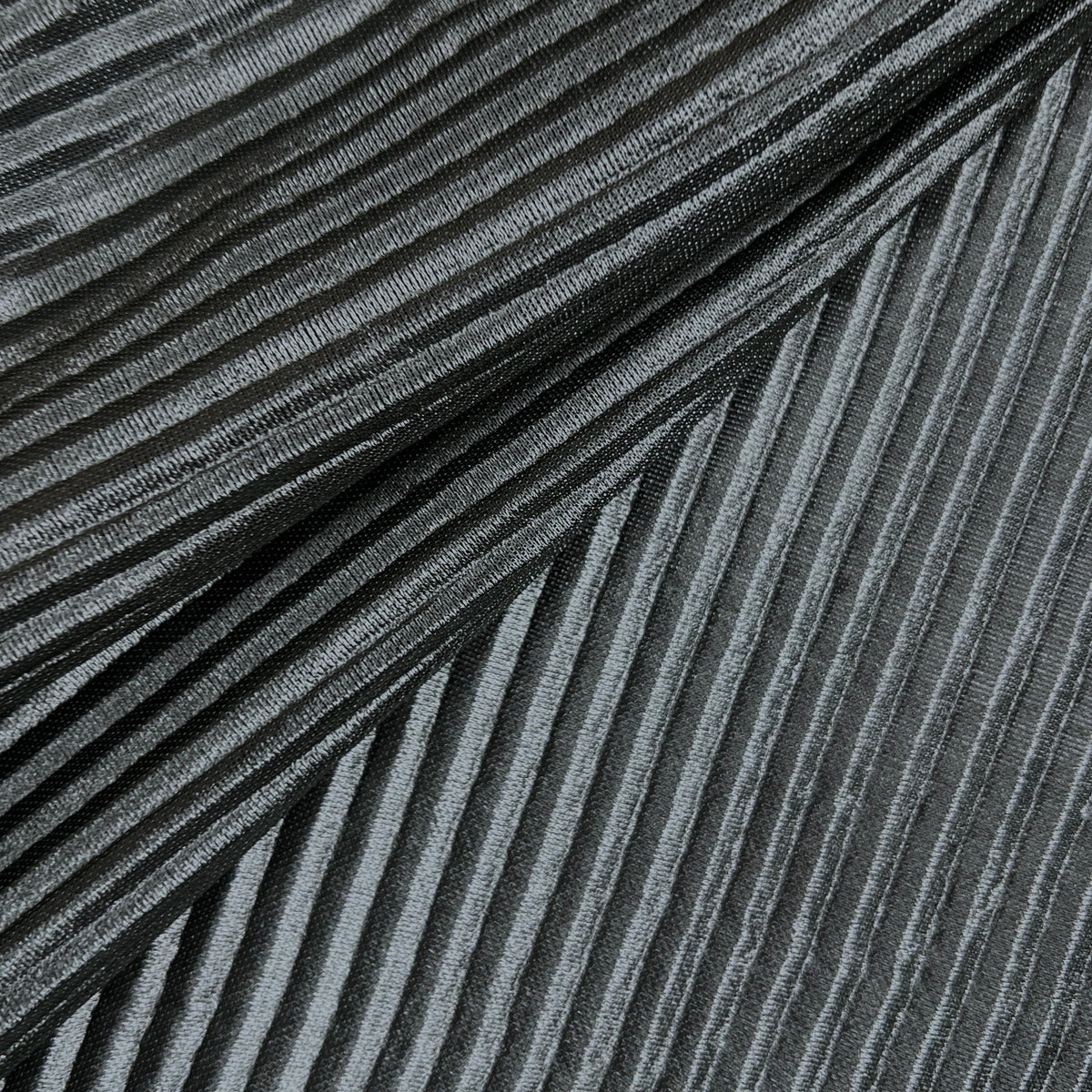 A close-up of a dark gray pleated fabric with a textured, metallic-like sheen, arranged diagonally.