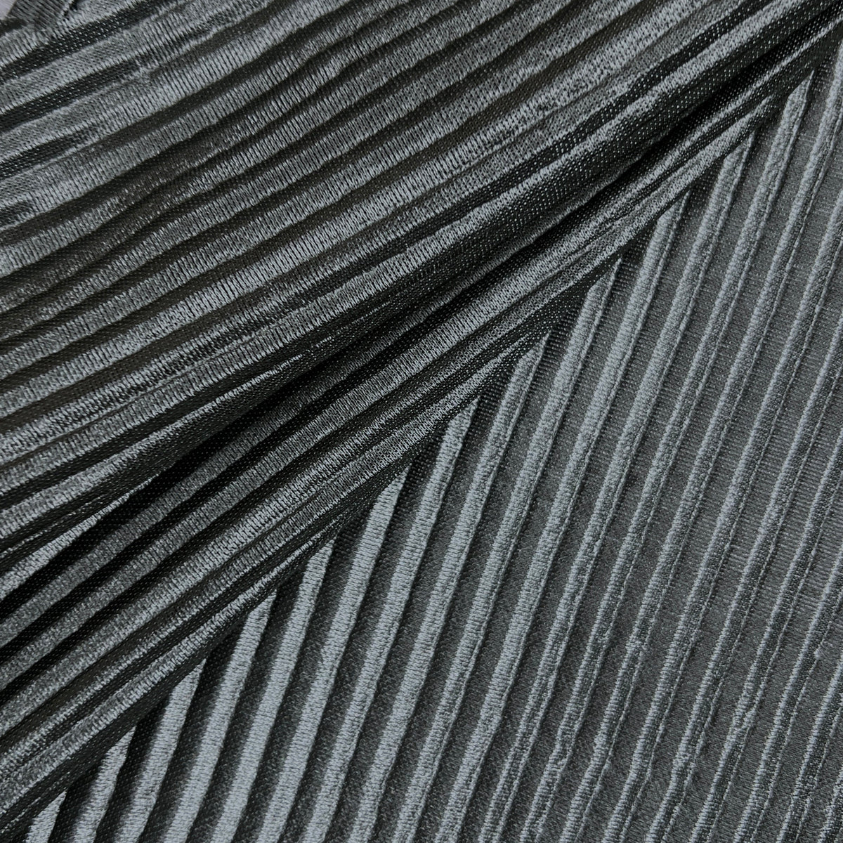 A close-up of a dark gray pleated fabric with a textured, metallic-like sheen, arranged diagonally.