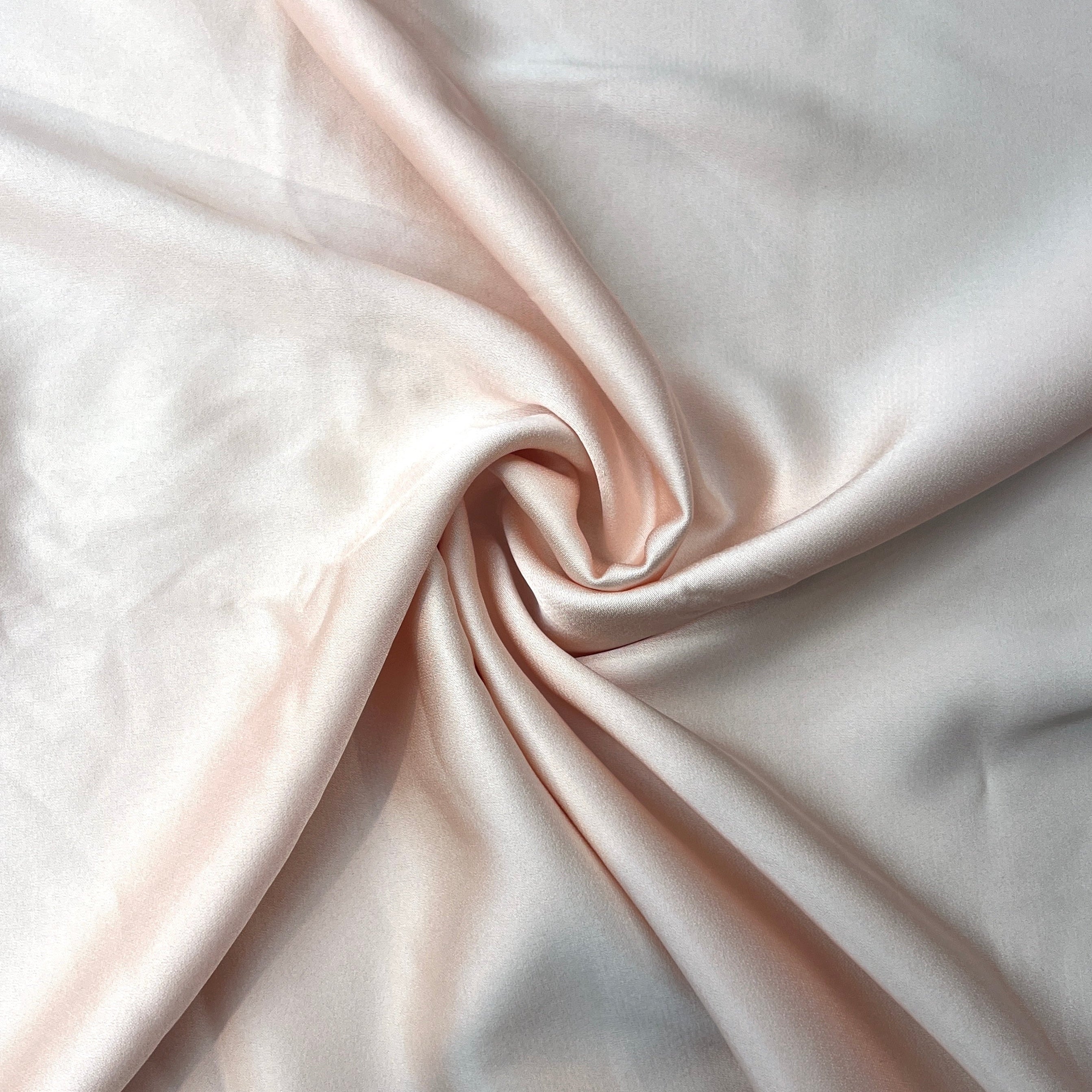 Close-up of pink satin fabric with a swirl pattern