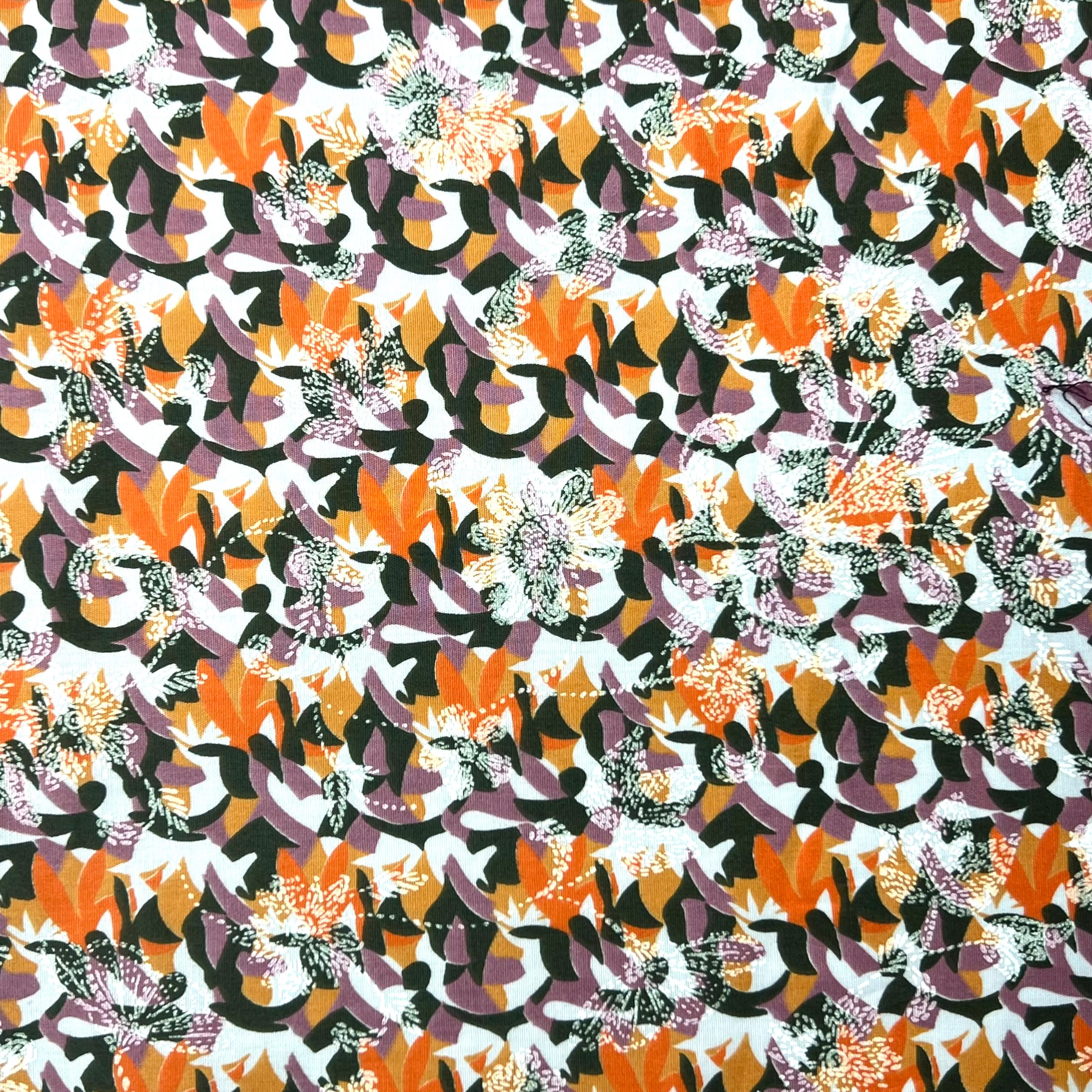 Patterned fabric with abstract design in orange, purple, and white on a black background
