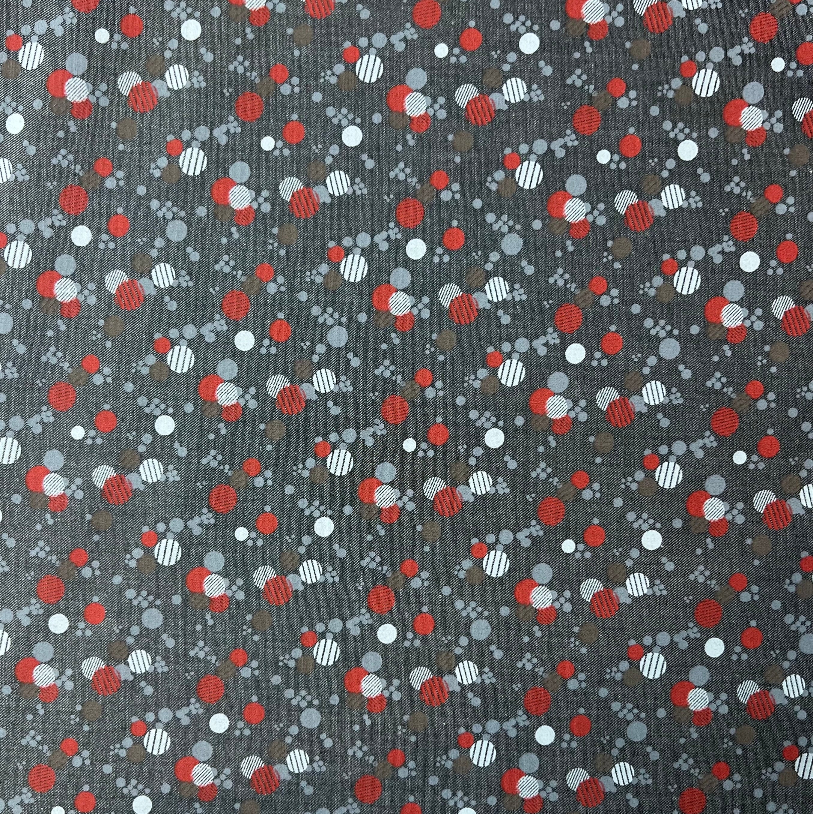Patterned fabric with red, white, and gray dots on a dark background