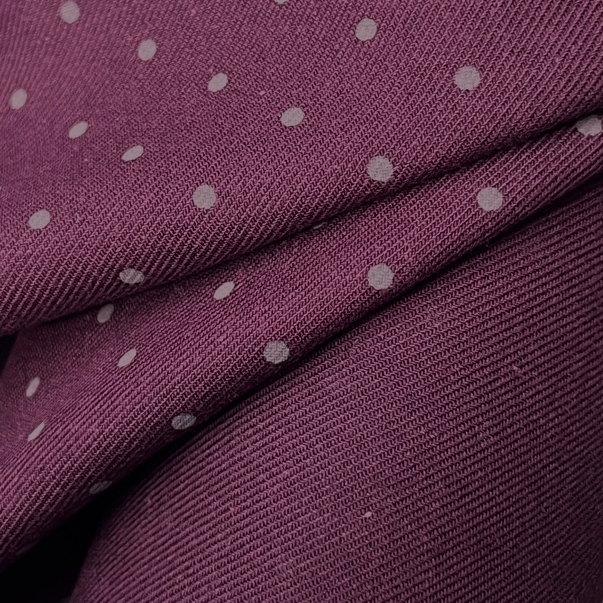 Close-up of purple fabric with white polka dots