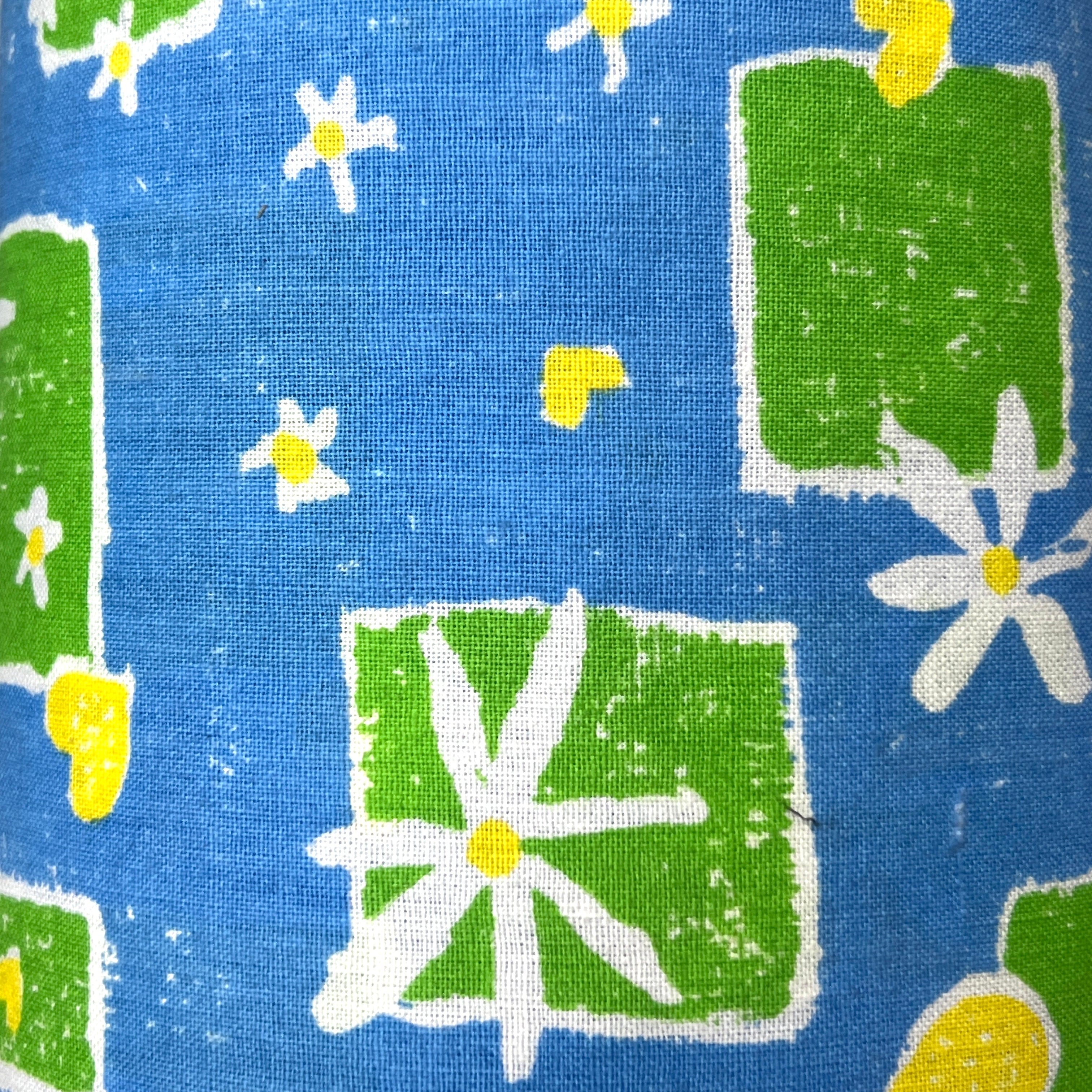 Fabric with green squares and white flowers on a blue background