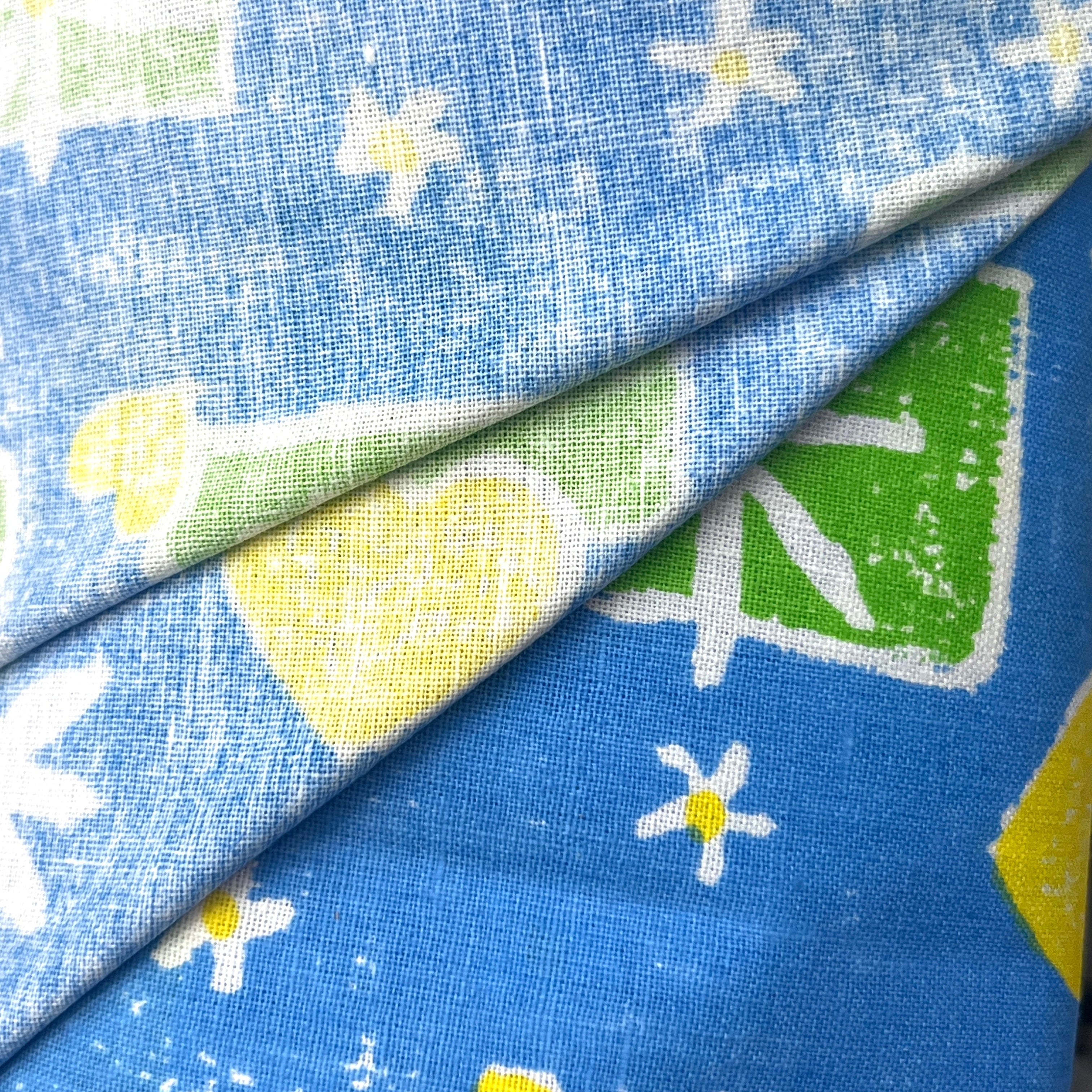 Close-up of blue fabric with white flowers and green shapes
