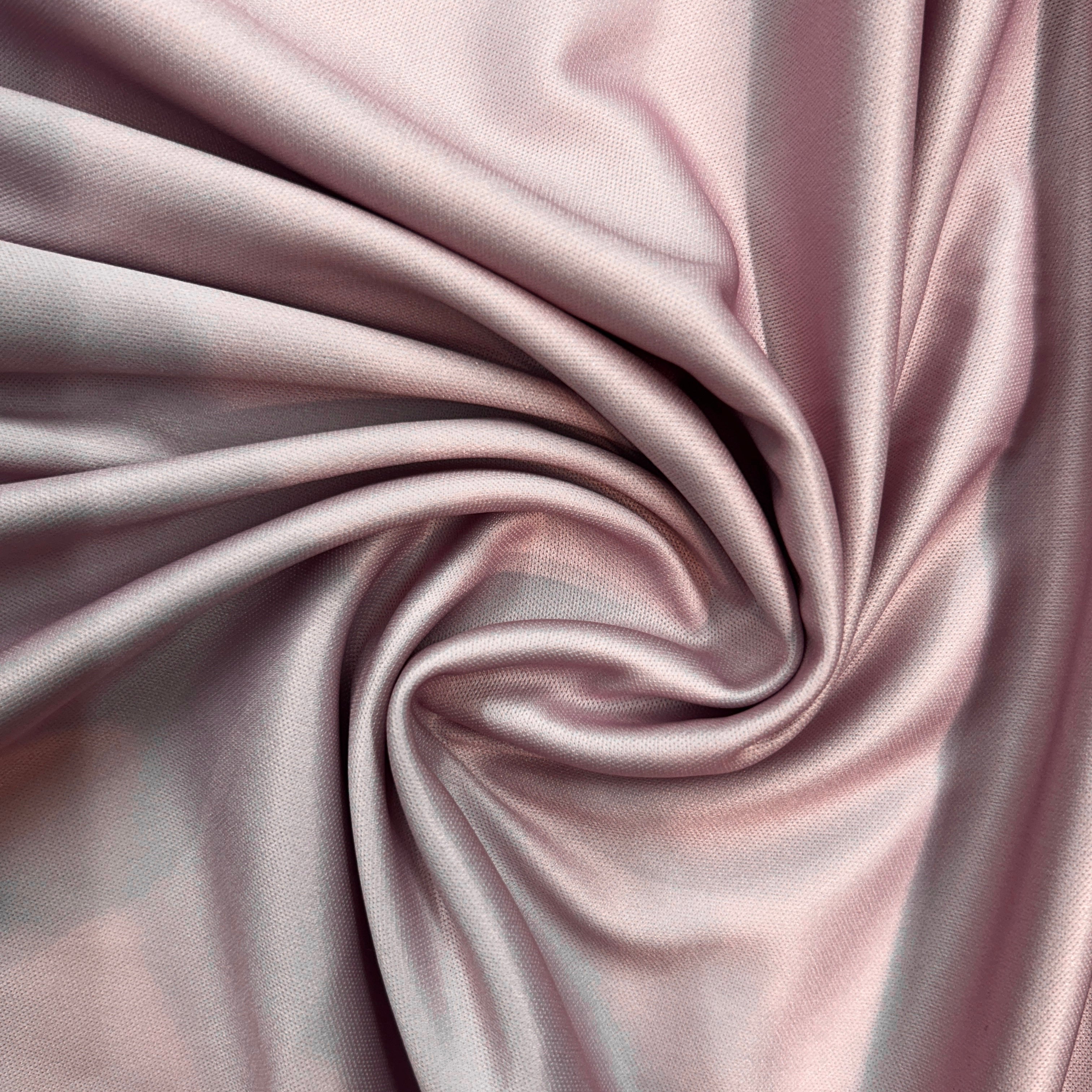 Close-up of pink satin fabric with folds