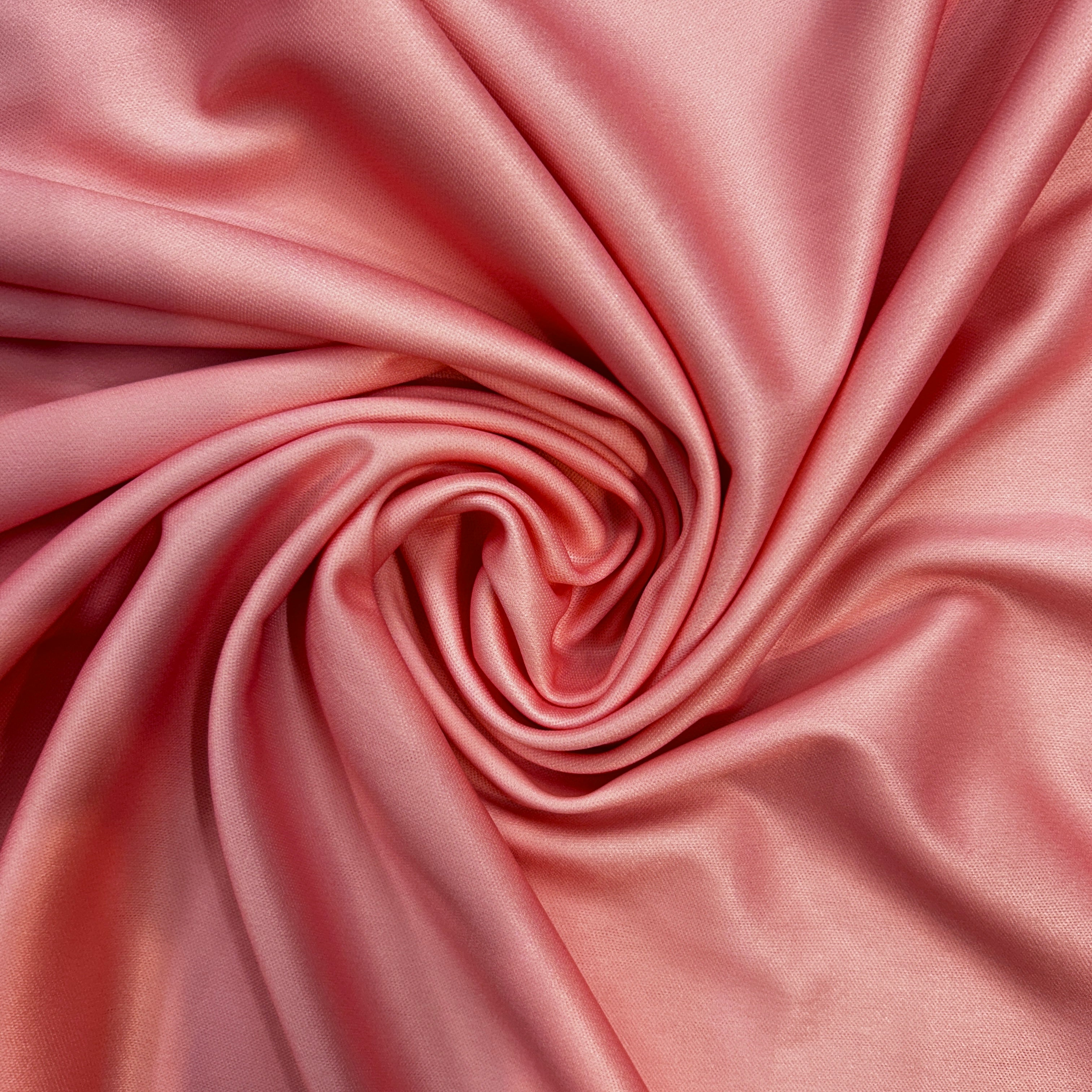 Close-up of pink satin fabric with a swirl pattern