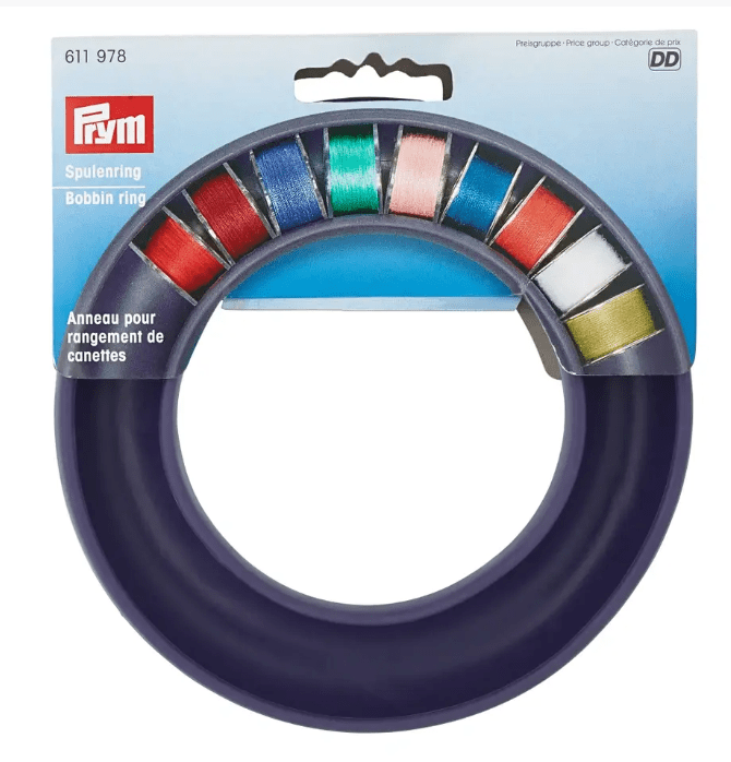 Prym bobbin ring in purple plastic with colorful spools of thread.