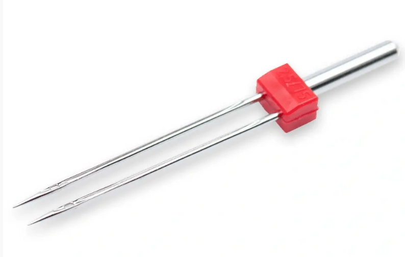 Silver double sewing machine needle with red plastic holder.