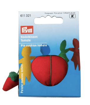 Red and green tomato-shaped pincushion with a small strawberry needle sharpener.