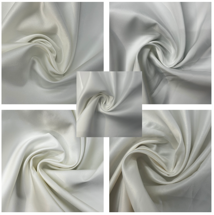 Close-up of white fabric with folds and swirls in a grid pattern.