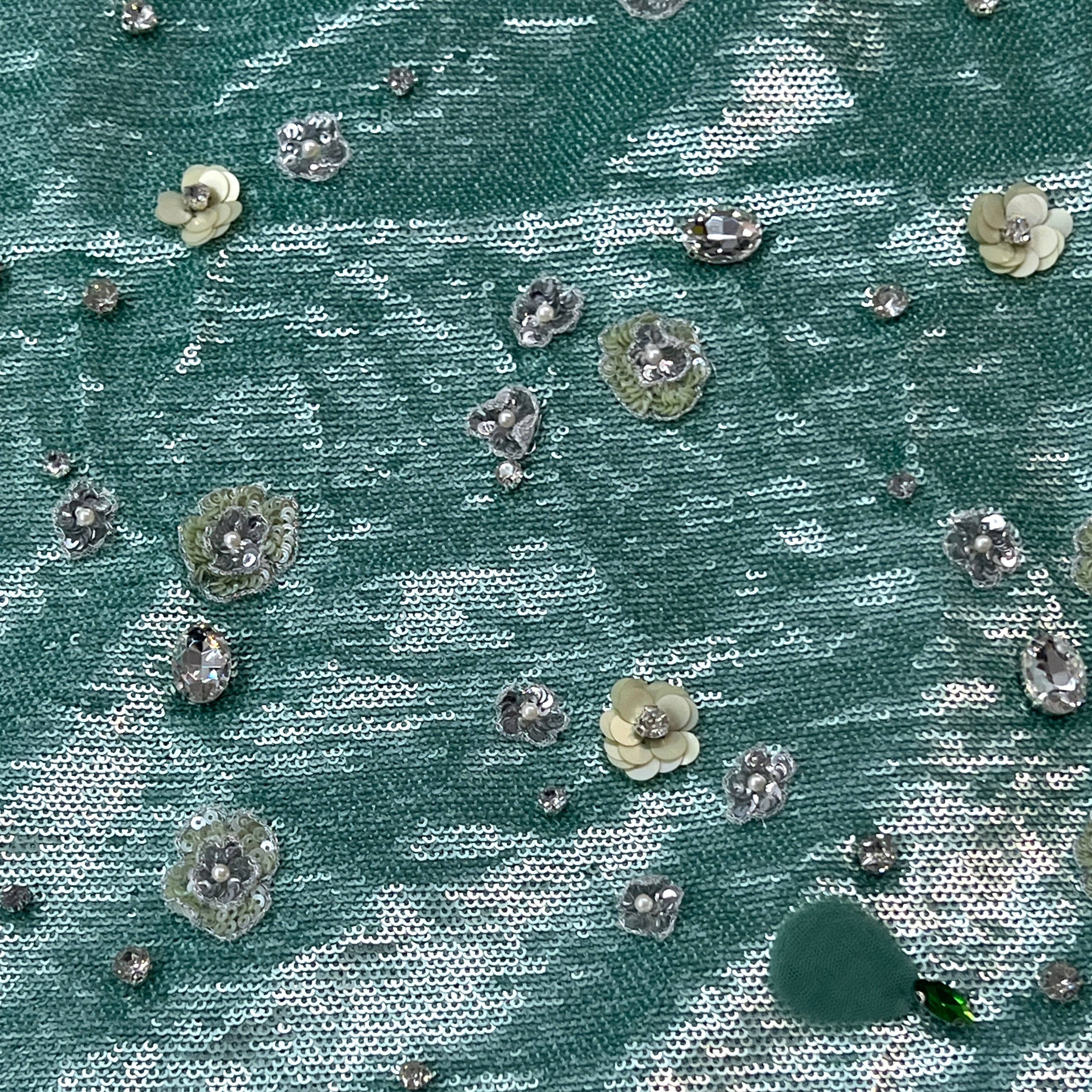 Textured fabric with floral embellishments on a teal background