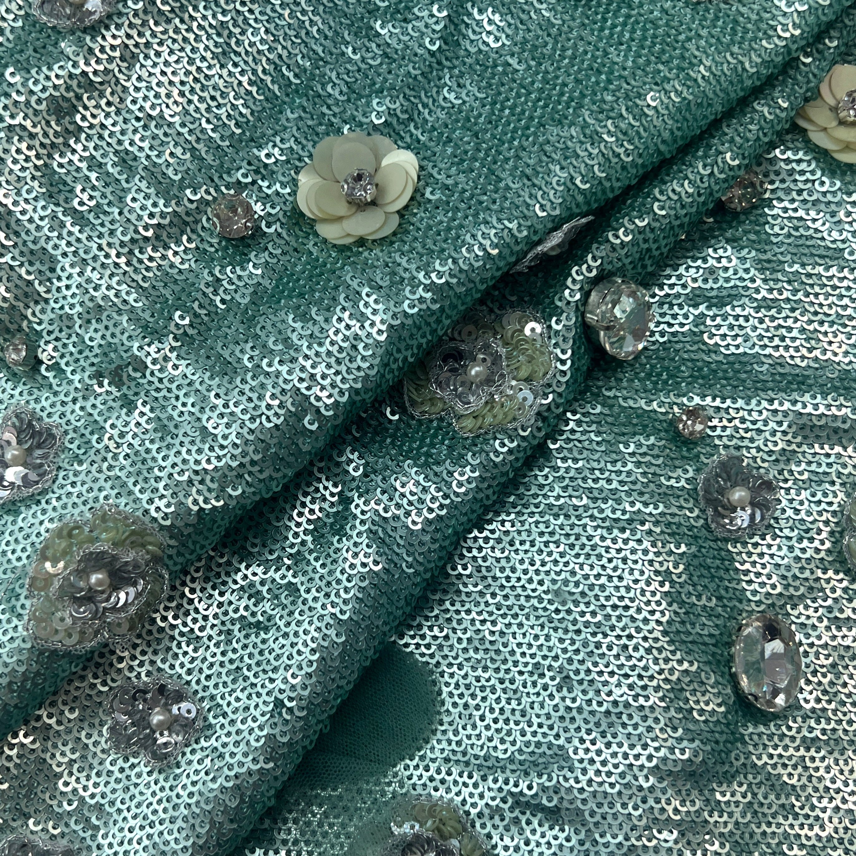 Teal sequin fabric with floral embellishments