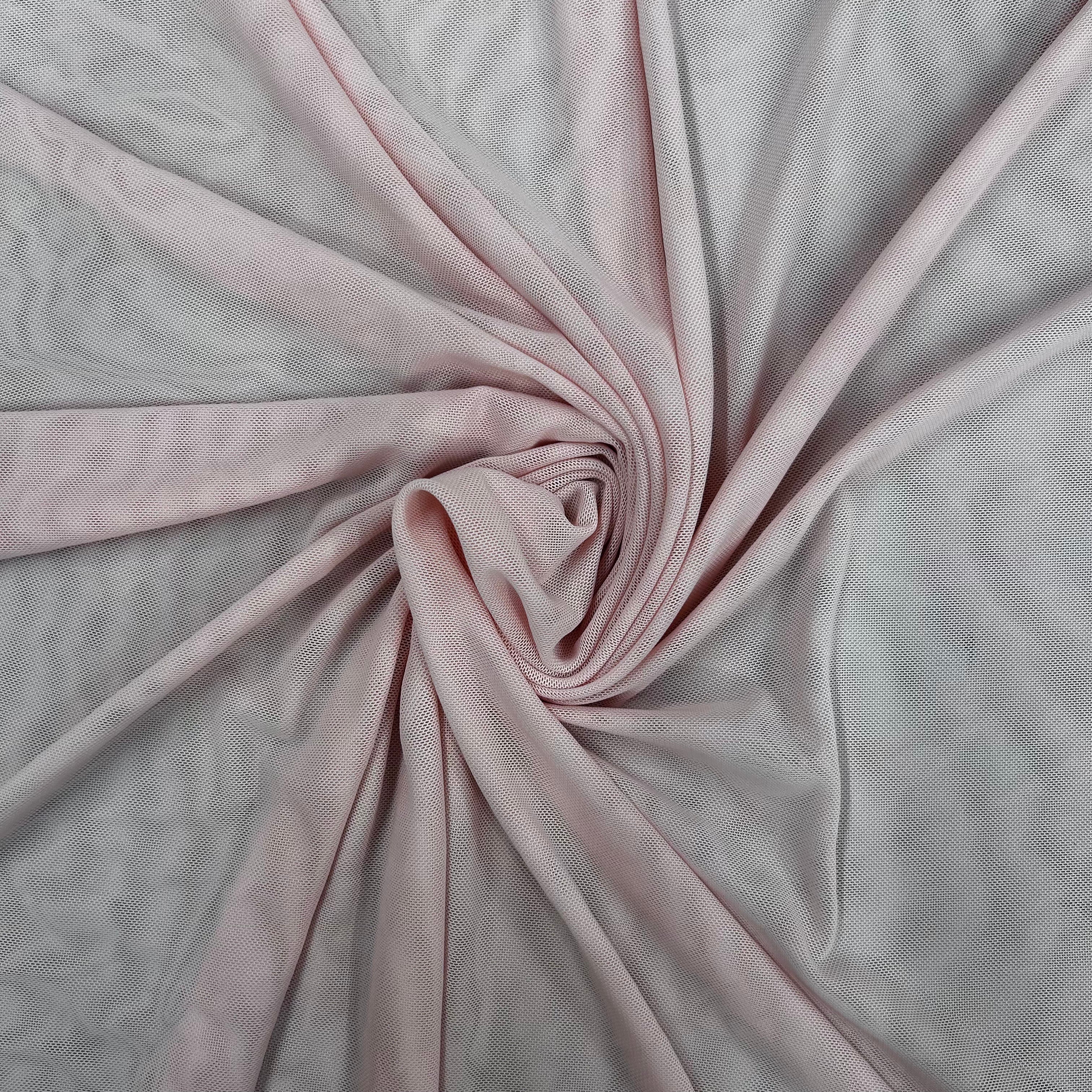 Pink fabric with a swirl pattern on a light gray background