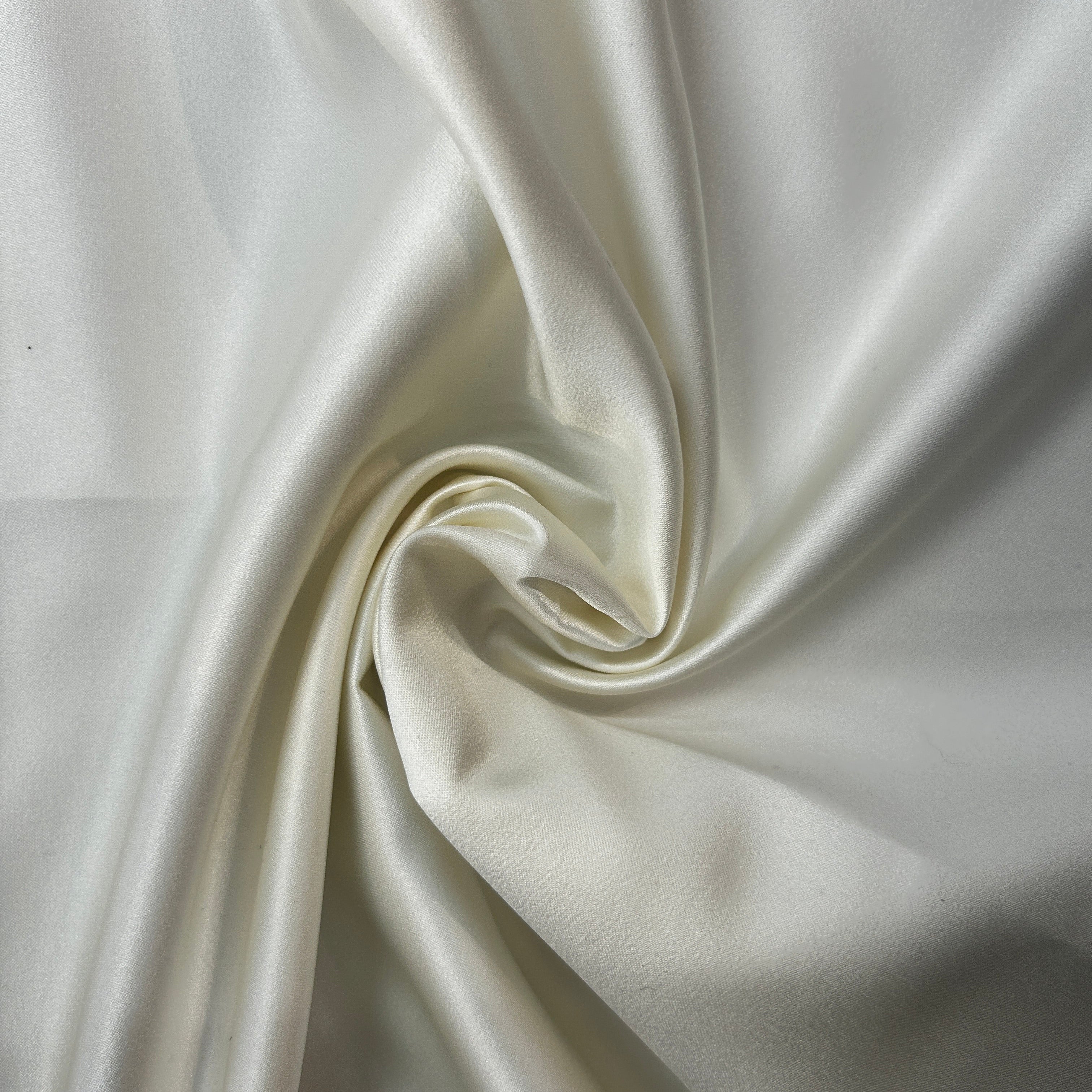 Close-up of white satin fabric with a swirl pattern