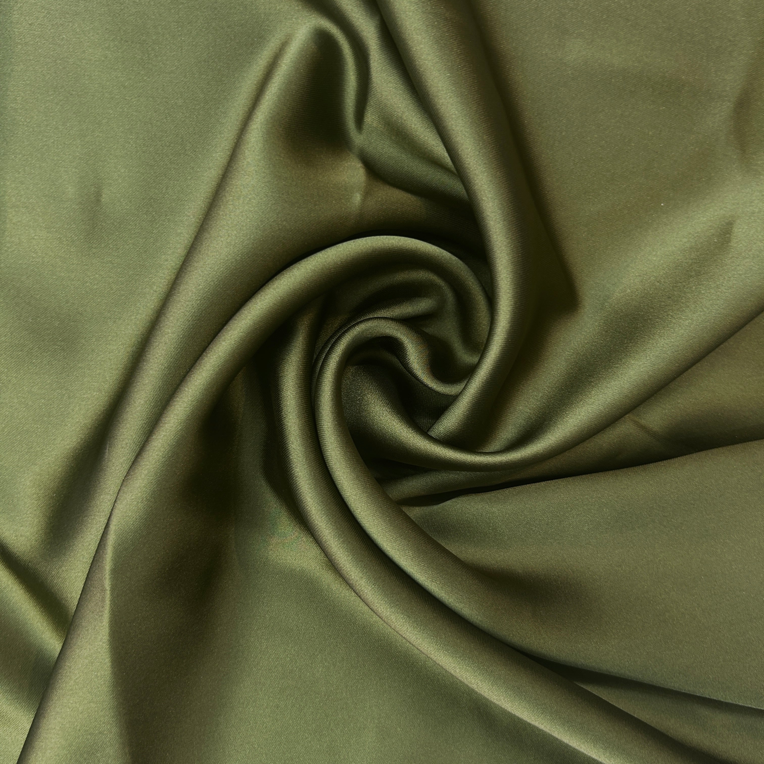 Close-up of olive green fabric with a swirl pattern