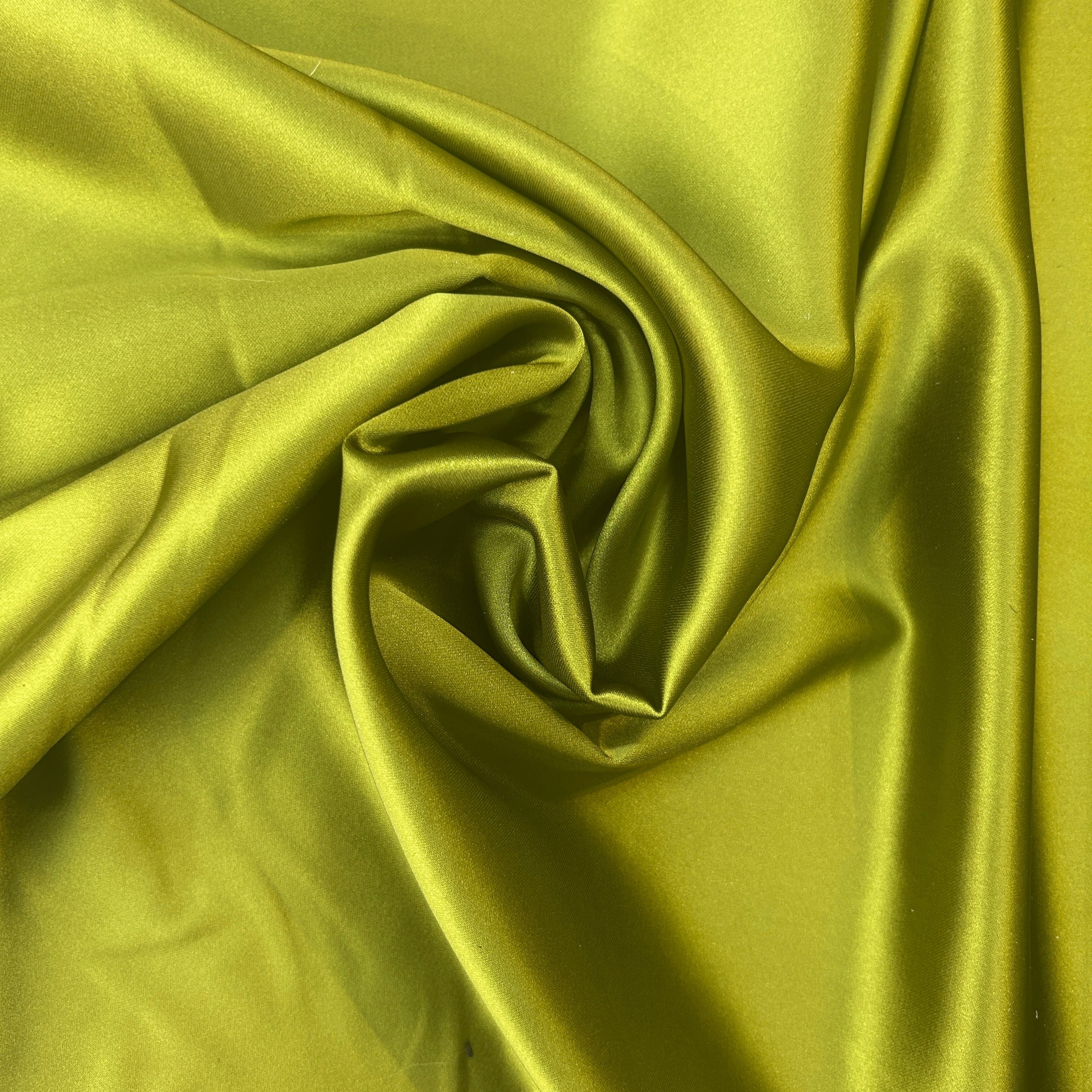 Close-up of green satin fabric with folds